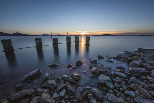 Italien, Umbrien, Perugia, Trasimeno-See, Holzpfähle bei Sonnenuntergang - LOMF00568