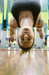 Frau übt Aerial Yoga im Unterricht - MGOF03243