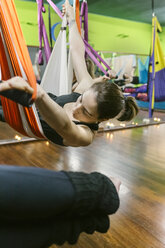 Frau übt Aerial Yoga im Unterricht - MGOF03246