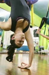 Frau übt Aerial Yoga im Unterricht - MGOF03250