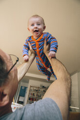 Father lifting up happy three-month-old baby at home - MFF03479