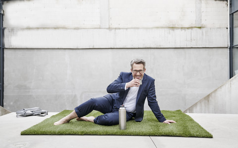 Lachender Geschäftsmann in einer Kaffeepause, lizenzfreies Stockfoto