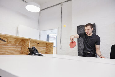 Young businessman playing table tennis in office - RHF01861