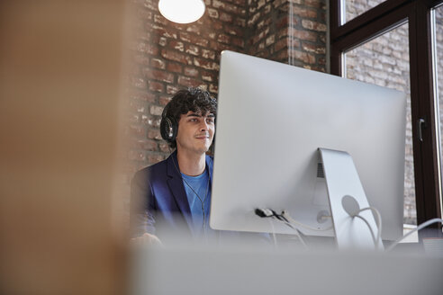 Junger Mann arbeitet im Büro, - RHF01867