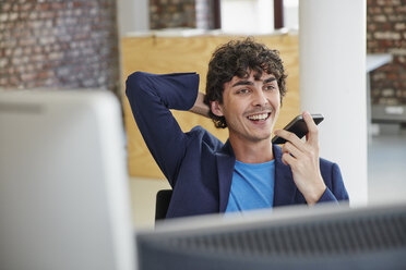 Junger Mann arbeitet im Büro und hinterlässt eine Sprachnachricht - RHF01868