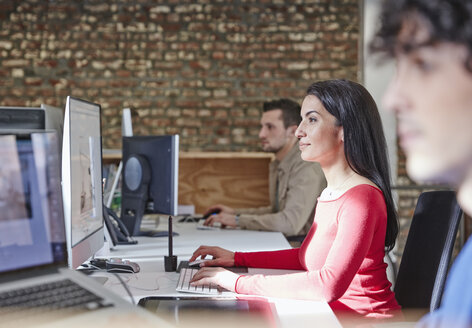 Reife Frau arbeitet im Büro mit jungen Kollegen - RHF01869