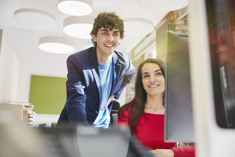 Junger Mann und Frau arbeiten zusammen im Büro, lizenzfreies Stockfoto