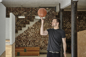 Junger Mann im Büro spielt mit Basketball - RHF01908