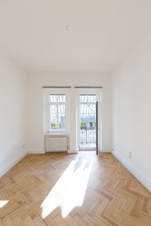 Empty room with herringbone parquet and opened balcony door - FCF01166