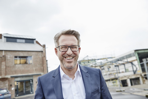 Portrait of laughing mature businessman outdoors stock photo