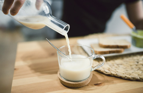 Pouring milk into a glass cup stock photo