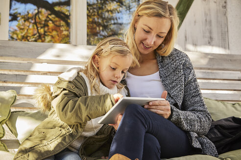 Mother with daughter on bench using tablet - KDF00723