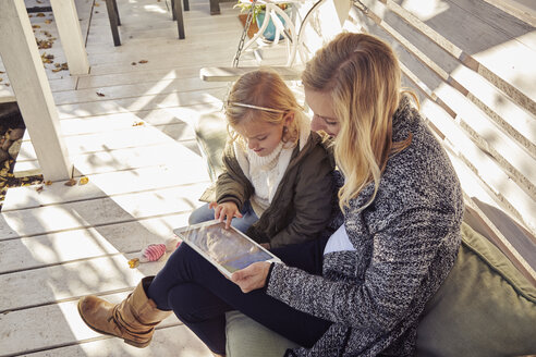 Mother with daughter on bench using tablet - KDF00724