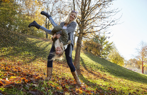 Mutter und Tochter spielen im Park im Herbst, lizenzfreies Stockfoto