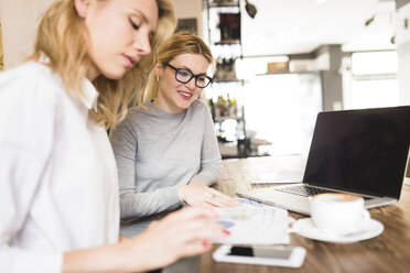 Zwei Geschäftsfrauen arbeiten gemeinsam an einem Projekt - FMOF00186