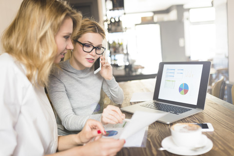 Zwei Geschäftsfrauen arbeiten gemeinsam an einem Projekt, lizenzfreies Stockfoto