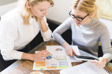 Zwei Geschäftsfrauen arbeiten gemeinsam an einem Projekt - FMOF00194