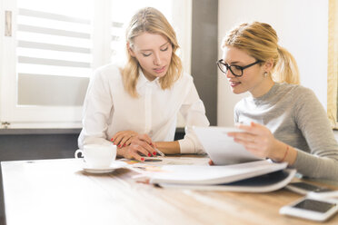 Zwei Geschäftsfrauen arbeiten gemeinsam an einem Projekt - FMOF00195