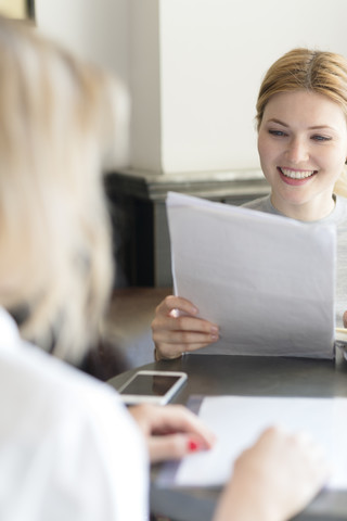 Lächelnde Frau beim Lesen eines Dokuments, lizenzfreies Stockfoto