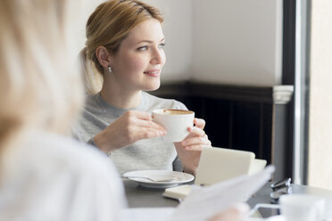 Lächelnde Frau in einem Cafe - FMOF00205