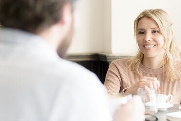 Smiling woman looking at man in a cafe - FMOF00208