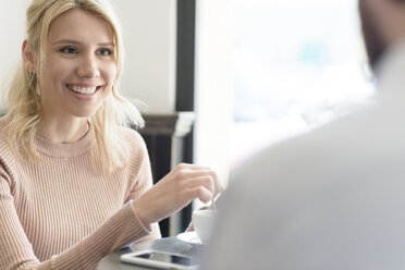 Smiling woman looking at man in a cafe - FMOF00209