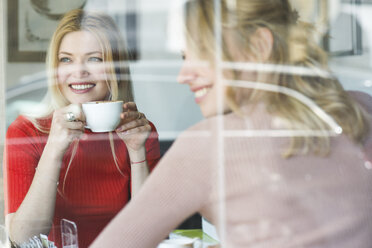 Zwei lächelnde junge Frauen in einem Cafe - FMOF00211