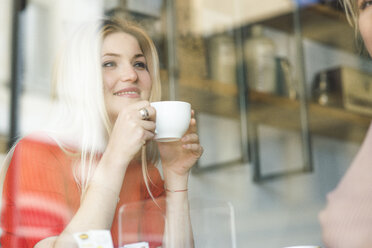 Smiling young woman in a cafe - FMOF00212