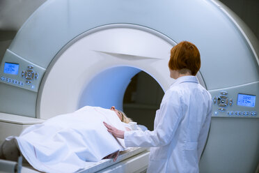 Ärztin bereitet Patientin für Magnetresonanztomographie vor - MWEF00140