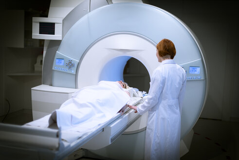 Ärztin bereitet Patientin für Magnetresonanztomographie vor - MWEF00143