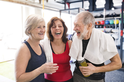 Gruppe glücklicher Senioren im Fitnessstudio, die eine Pause machen, lizenzfreies Stockfoto