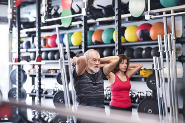 Älterer Mann und Frau im Fitnessstudio beim Training mit Medizinbällen - HAPF01479