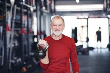 Älterer Mann beim Training mit der Kettlebell im Fitnessstudio - HAPF01482