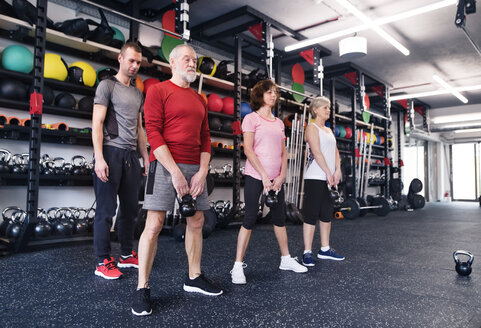 Gruppe von fitten Senioren mit Personal Trainer im Fitnessstudio - HAPF01483