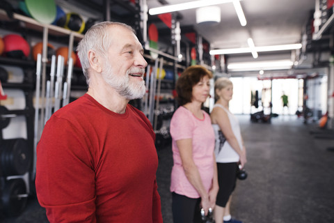 Gruppe von fitten Senioren im Fitnessstudio beim Training mit Kettlebells, lizenzfreies Stockfoto