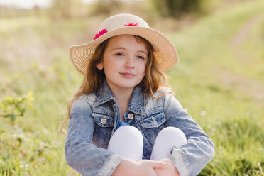 Portrait of girl wearing straw hat sitting on a meadow - NMSF00048