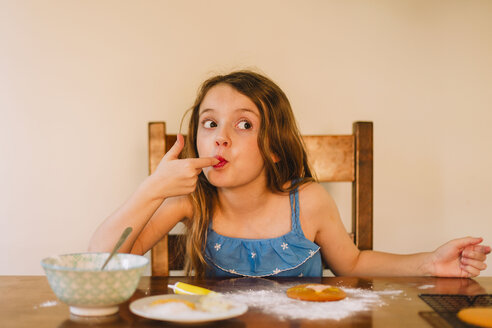 Portrait of girl decorating biscuits at home - NMSF00054