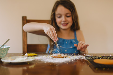 Mädchen dekoriert Kekse zu Hause, lizenzfreies Stockfoto