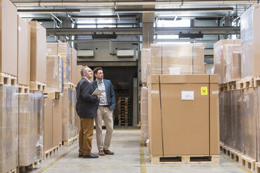 Two men standing in factory warehouse - DIGF01751