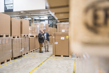 Two men standing in factory warehouse - DIGF01752