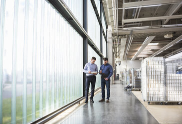 Two men in factory shop floor examining product - DIGF01826