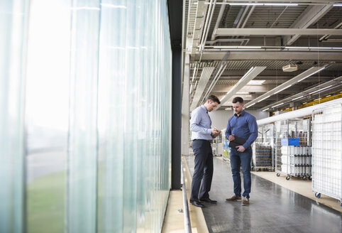 Two men in factory shop floor examining product - DIGF01827