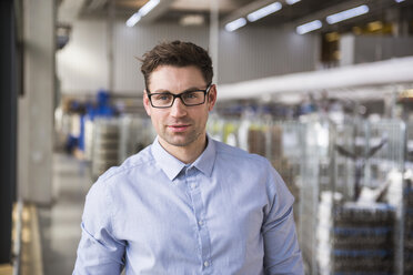 Portrait of confident businessman in factory shop floor - DIGF01835