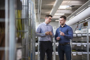 Two men in factory shop floor examining product - DIGF01842