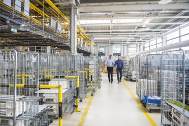 Two men walking in factory shop floor - DIGF01847