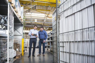 Two men with tablet talking in factory shop floor - DIGF01853