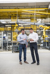 Two men with tablet talking in factory shop floor - DIGF01859