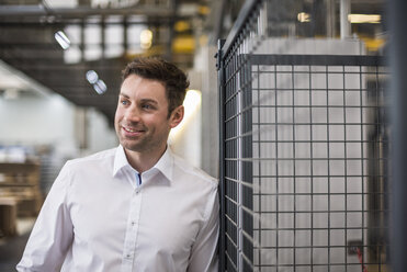 Portrait of confident businessman in factory shop floor - DIGF01877