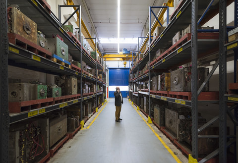 Geschäftsmann am Telefon in einer Lagerhalle einer Fabrik, lizenzfreies Stockfoto