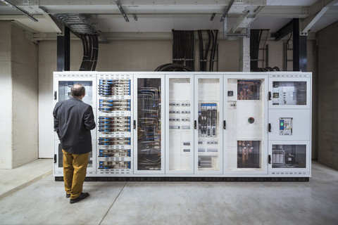 Businessman in factory looking at buffer storage of a photovoltaic plant stock photo